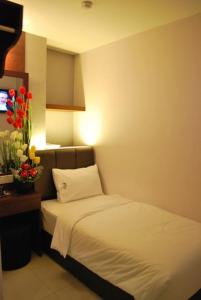 a hotel room with a bed and a vase of flowers at AVARIA SIGNATURE in Melaka