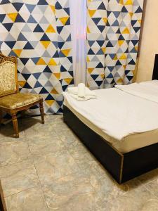 ein kleines Schlafzimmer mit einem Bett und einem Stuhl in der Unterkunft Villa Hotel in Yerevan