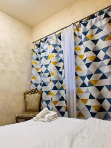 ein Schlafzimmer mit einem Bett, einem Stuhl und einem Fenster in der Unterkunft Villa Hotel in Yerevan