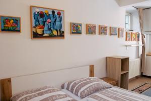 a bedroom with a bed and paintings on the wall at Budget dbl Studio free breakfast in Ljubljana