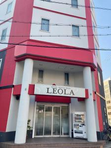 un edificio rojo y blanco con una tienda de leola en レオラ, en Osaka