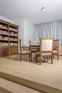 a dining room with a table and chairs and a book shelf at W15 Glenfall Nuwara Eliya in Nuwara Eliya