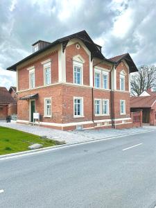 um grande edifício de tijolos na lateral de uma rua em betterplaces Boutique Apartments - Frontenhausen em Dingolfing