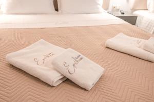 a bed with white towels on top of it at Epithea Suites Kythnos 5 με ιδιωτική πισίνα in Kithnos +25 photos
