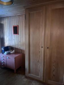 Habitación con puerta de madera y armario de madera. en Hotel KRONE habitación individual en Zäziwil
