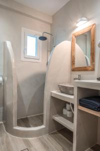 y baño con lavabo y espejo. en Epithea Suites Kythnos 5 με ιδιωτική πισίνα en Kíthnos