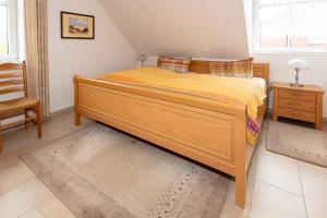 a bedroom with a large wooden bed and a chair at Ferienhaus Inselliebe in Borkum