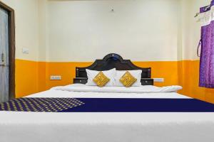 um quarto com uma cama grande com paredes amarelas e laranja em SPOT ON 81125 Hotel Ashirwad em Indore