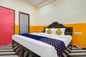 a large bed in a room with a red door at SPOT ON 81125 Hotel Ashirwad in Indore