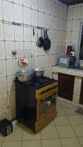 a kitchen with a stove with pots and pans on it at AU COEUR DE BONAMOUSSADI-WIFI-PARKING-GARDIENS-24H in Douala