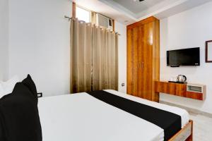 a bedroom with a bed and a flat screen tv at OYO HIGHWAY RESIDENCY in Gurgaon