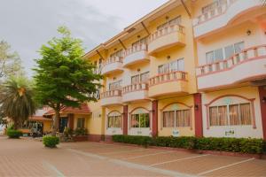 a yellow building with a tree in front of it at บ้านพร้อมพงศ์ Ban Prompong in Ban Chak Phai