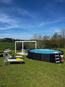 una piscina con una mesa y una silla en un campo en La casa terra dei sogni, en Castiglione del Lago