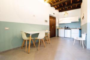 kuchnia i jadalnia ze stołem i krzesłami w obiekcie Via Camerina 3 w mieście Castelnuovo di Porto