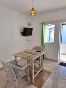 comedor con mesa de madera y sillas en Le Beau Manguier Residence, en Pereybere