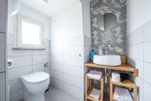 łazienka z toaletą i umywalką w obiekcie Via Camerina 3 w mieście Castelnuovo di Porto