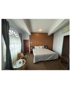 um quarto de hotel com uma cama e uma janela em The Valaya Hotel em Darjeeling