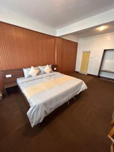um quarto com uma cama grande num quarto em The Valaya Hotel em Darjeeling
