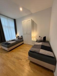 une chambre avec deux lits et une grande fenêtre dans l'établissement Apartments am Kaisersaal, à Erfurt