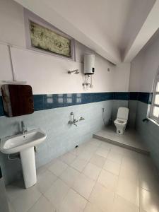 a bathroom with a sink and a toilet at The Valaya Hotel in Darjeeling