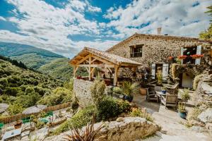 a stone house with a view of mountains at La Calade Chambres d'Hôtes & Espace Bien-Etre in Chirols
