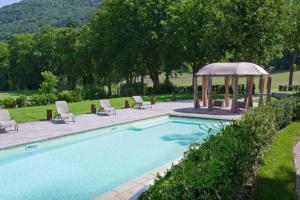 una piscina con cenador, sillas y cenador en Ferienhaus für 20 Personen in Gubbio-Nerbisci, Ubrien Provinz Perugia, en Mocaiana