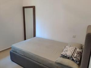 een bed in een kamer met een spiegel bij Canterbury Apartments - Kahathuduwa Gonapola in Gonapola