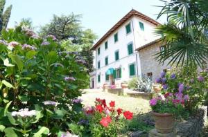 un jardin fleuri devant un bâtiment dans l'établissement Ferienhaus für 10 Personen in Uzzano, Toskana Provinz Pistoia, à Uzzano