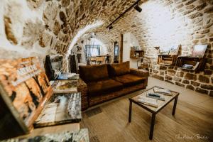 a living room with a couch and a table at La Calade Chambres d'Hôtes & Espace Bien-Etre in Chirols