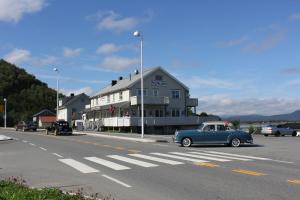 an old blue car parked in front of a building at Ulvsvåg Gjestgiveri og Fjordcamping AS in Ulvsvåg