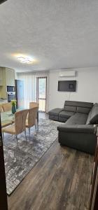 uma sala de estar com um sofá e uma mesa em Д и В 3 - D & V 3 Apartment em Sandanski