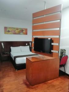 1 dormitorio con 1 cama y TV de pantalla plana en Hotel AW Boutique, en Bogotá