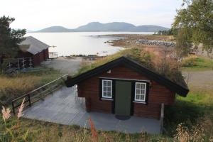 a small cabin on the shore of a lake at Ulvsvåg Gjestgiveri og Fjordcamping AS in Ulvsvåg