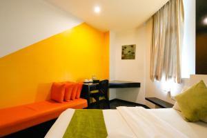 a hotel room with a bed and a desk at Golden Roof Hotel Ampang Ipoh in Ipoh