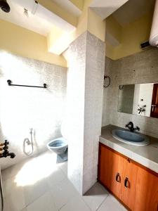 La salle de bains est pourvue d'un lavabo et de toilettes. dans l'établissement Yesheyzz Homestay, Upper Sichey, Gangtok, à Gangtok