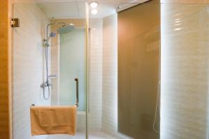 a shower with a glass door in a bathroom at Golden Roof Hotel Ampang Ipoh in Ipoh