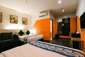 ein Hotelzimmer mit 2 Betten und einem Sofa in der Unterkunft Golden Roof Hotel Ampang Ipoh in Ipoh