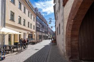 a street with people riding a bike down a street at Altstadt Apartment for 2 in Erfurt