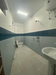 La salle de bains est pourvue de 2 lavabos et de toilettes. dans l'établissement The Valaya Hotel, à Darjeeling