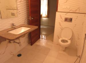 ein weißes Bad mit einem Waschbecken und einem WC in der Unterkunft White Camel companies in Hyderabad
