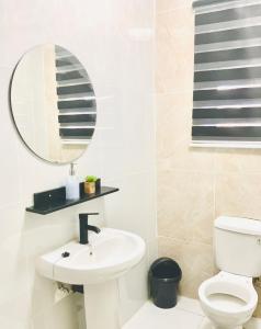 a white bathroom with a sink and a mirror at Monaco villa Palapye in Palatswe