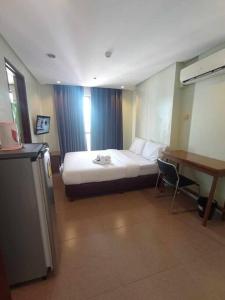 une chambre d'hôtel avec un lit et un bureau dans l'établissement Spacious Studio Apartment B501, à Manille