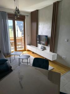a living room with a flat screen tv on a table at Katalina Zlatibor in Čajetina +14 photos