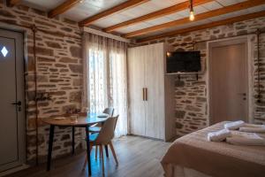 a bedroom with a table and a room with a bed at Epithea Suites Kythnos Keli in Kithnos