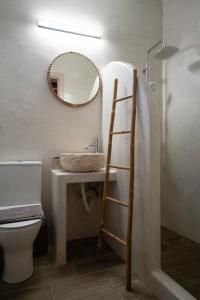 a bathroom with a sink and a mirror at Epithea Suites Kythnos Keli in Kithnos +14 photos