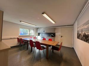 comedor con mesa y sillas rojas en Mieterlux Frankfurt Heusenstamm 46, en Heusenstamm