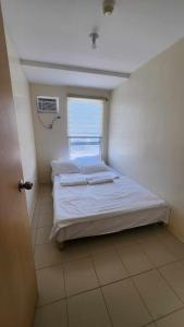 a bedroom with a bed in a room with a window at URBAN DECA Homes SM EAST Pasig in Manila