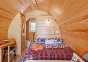 ein Schlafzimmer mit einem Bett in einem Holzzimmer in der Unterkunft Clywedog in Cyffylliog