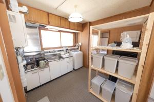 a kitchen with white appliances in a room at +C FURANO in Furano