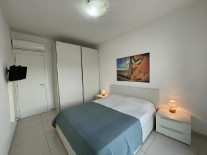 um pequeno quarto com uma cama e duas mesas de cabeceira em Appartamento Al Faro I TerraceRelax&Parking em Lignano Sabbiadoro